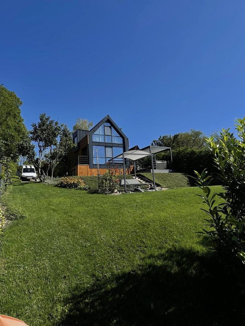 Turnkey garden around a modern family house, with a kept lawn, a flower bed and shading – near Győr