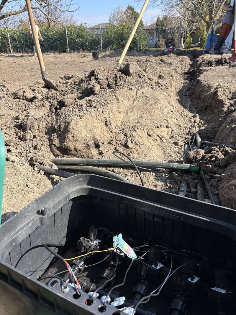 Open irrigation valve box with solenoid valves, and the pipe network laid in a trench